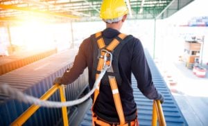 working wearing fall protection harness