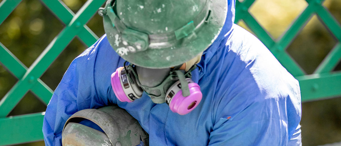 Outdoor worker wearing a respirator to protect from airborne particles generated from the job task.