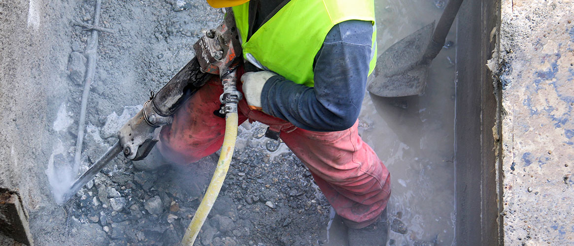 Jackhammer operator cutting into concrete which may contain silica