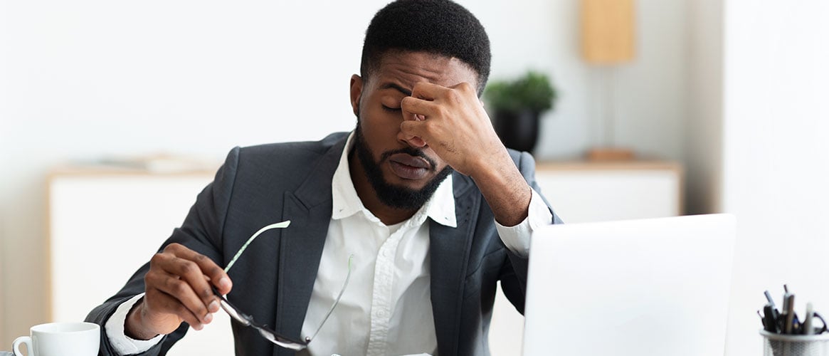 Stressed employee at his desk reacting to the workplace pressures