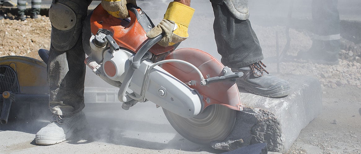 Construction worker cutting stone, producing dust that could contain silica particles