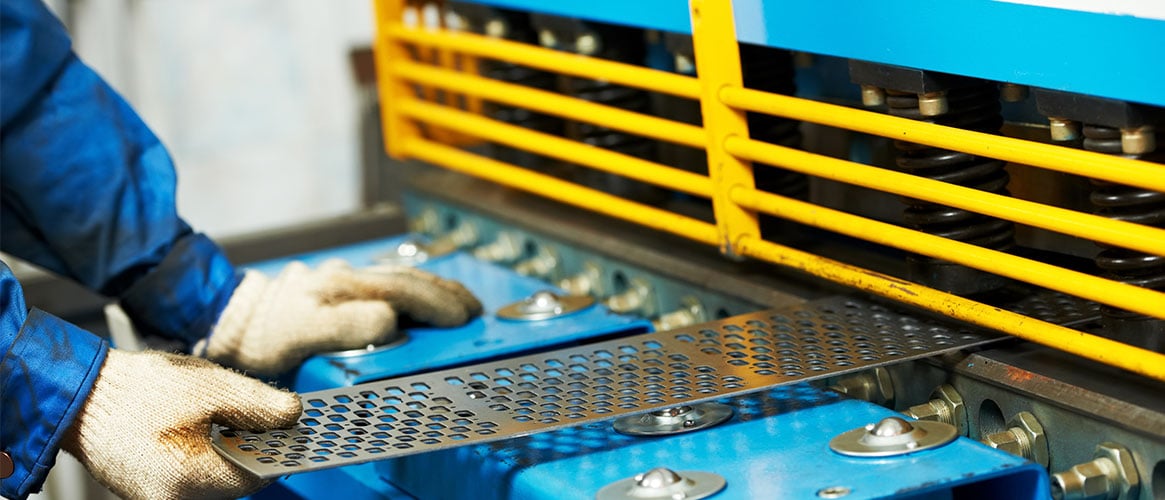 Worker inserting sheet metal into a machine