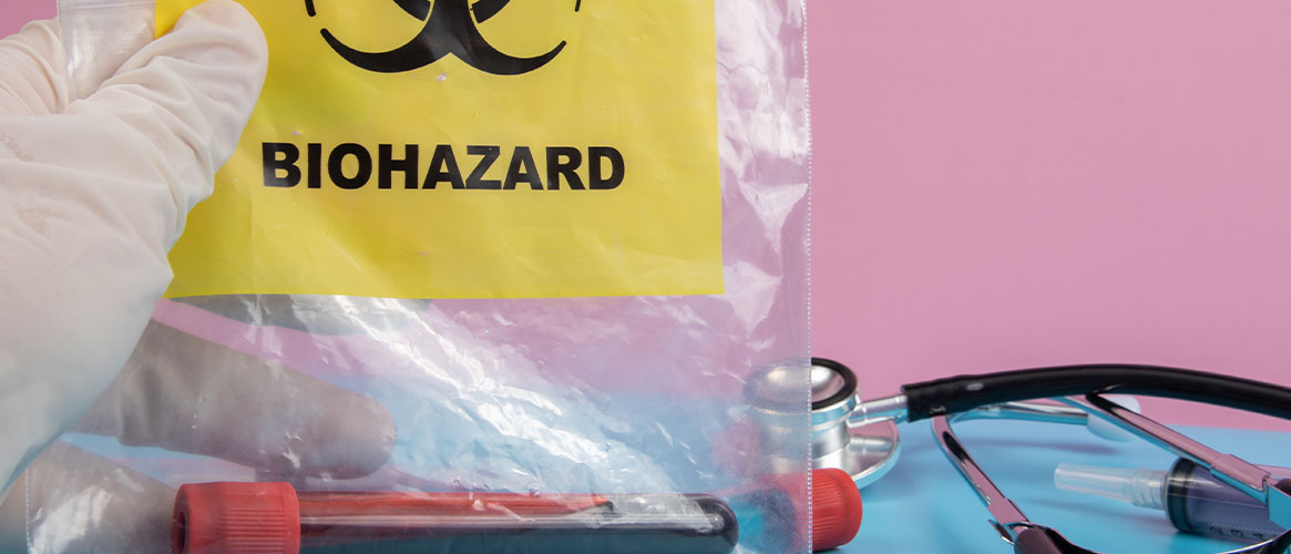 Medical professional holding a biohazard bag containing a blood sample.
