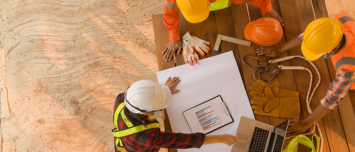 Construction workers discussing use of safety gear in preparation for work