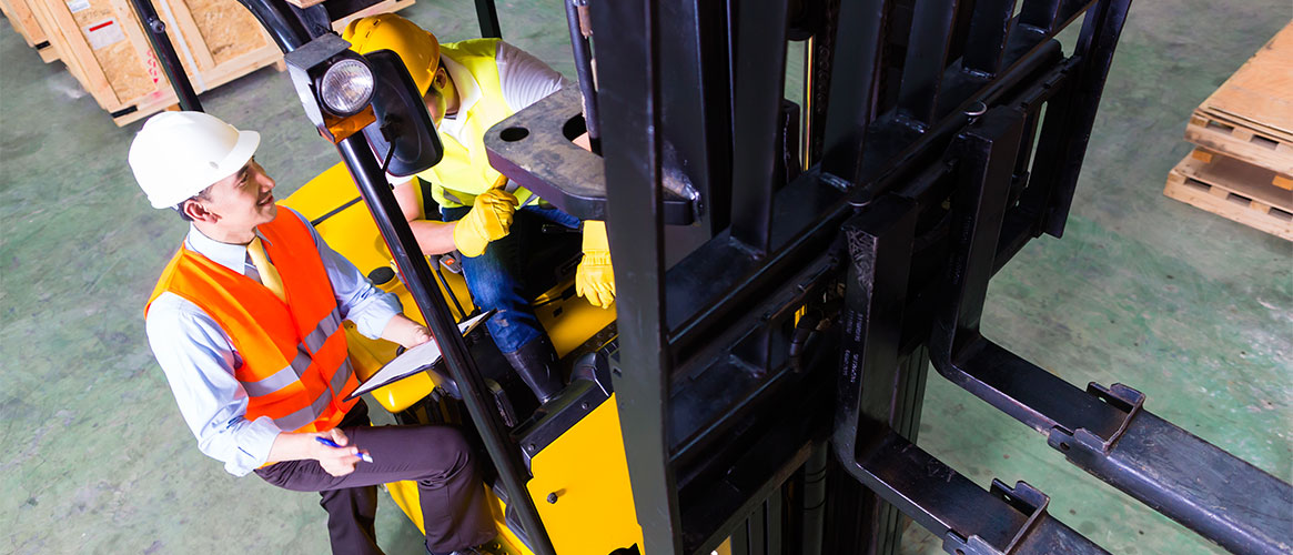 Forklift driver speaking with supervisor in a warehouse