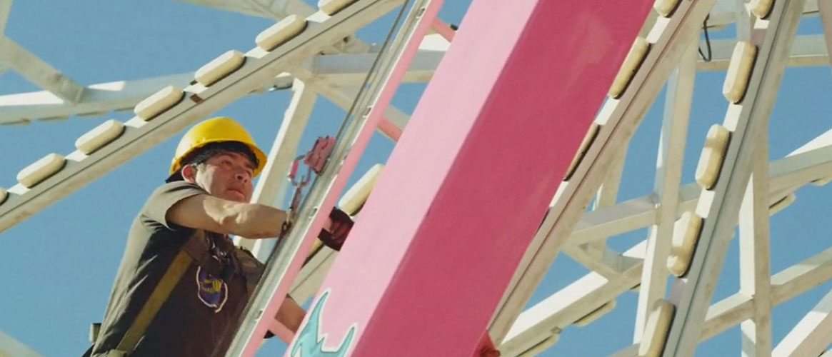Butler Amusements worker climbs Ferris wheel for maintenance.
