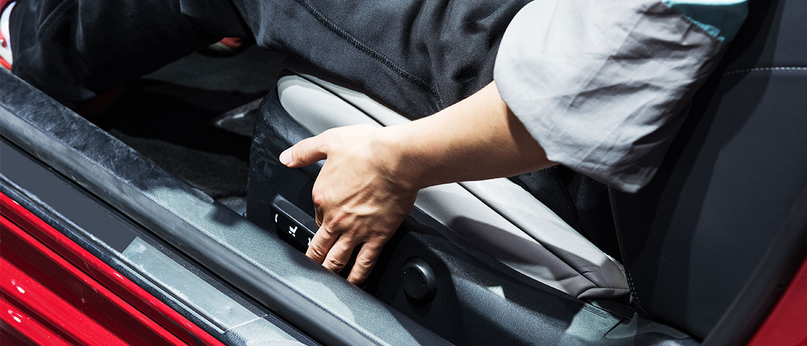 Employee adjusting the seat to ensure good vehicle ergonomics while driving.